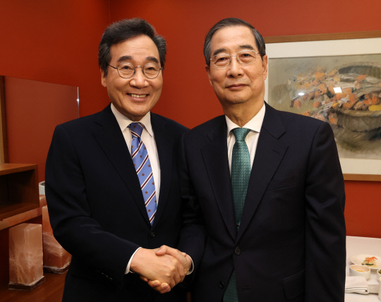 지난 5월6일 서울 중구 컨퍼런스하우스달개비에서 무소속 제21대 대선 예비후보인 한덕수(오른쪽) 전 국무총리와 새미래민주당 상임고문인 이낙연 전 총리가 오찬 회동을 하기 전 악수하고 있다.<공동취재·연합뉴스>